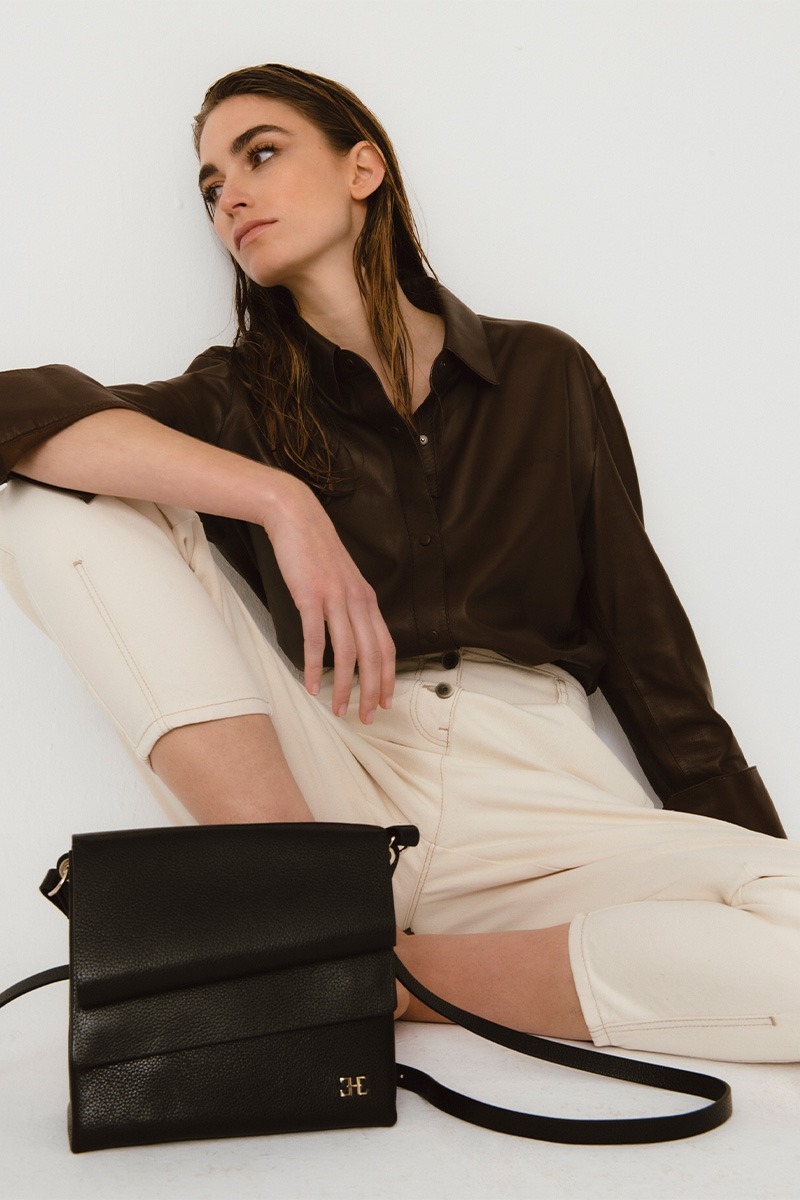 Mujer posando con Bolso de piel negro marca HedenBrand, colección Drape Shoulder Square PM